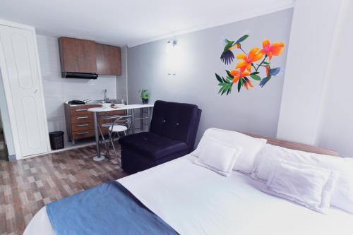 a bedroom with a bed and a chair and a desk at ApartaSuites & Hotel Bogota Suamox in Bogotá