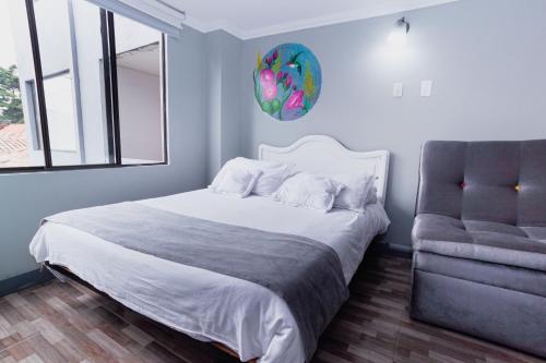 a bedroom with a bed and a chair at ApartaSuites & Hotel Bogota Suamox in Bogotá