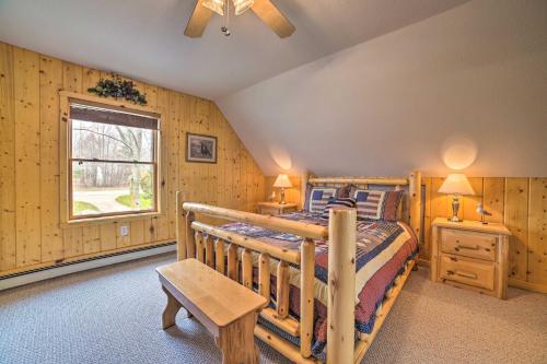 een slaapkamer met een houten bed en een raam bij Waterfront Lake Huron Home - Private Beach! in Tawas City