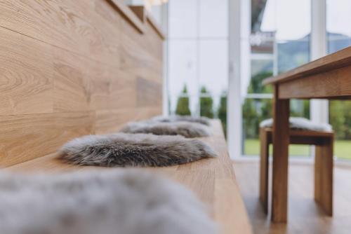 a row of fur pillows sitting on a wooden table at Spa Chalet by we rent in Zell am See