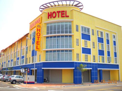 un hôtel jaune avec un panneau d'hôtel orange dans l'établissement Sun Inns Hotel Kuala Selangor, à Kuala Selangor