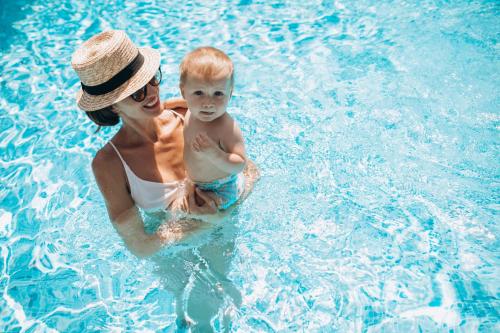 une femme tenant un bébé dans une piscine dans l'établissement Fracanzana Hotel, à Montebello Vicentino