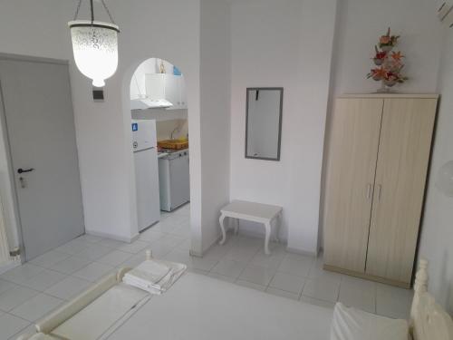 a white room with a kitchen and a table at Silver view in Batsi