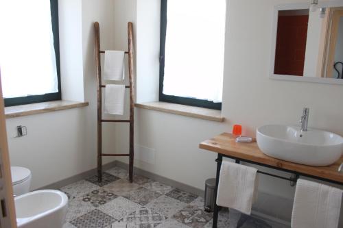 a bathroom with a sink and a toilet and a mirror at Il Granaio in Porto SantʼElpidio
