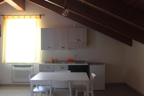 a kitchen with a white table and chairs and a window at Il Granaio in Porto SantʼElpidio