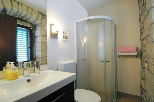 une salle de bain avec douche, lavabo et toilettes dans l'établissement Guesthouse Adriana Cottages, à Labin