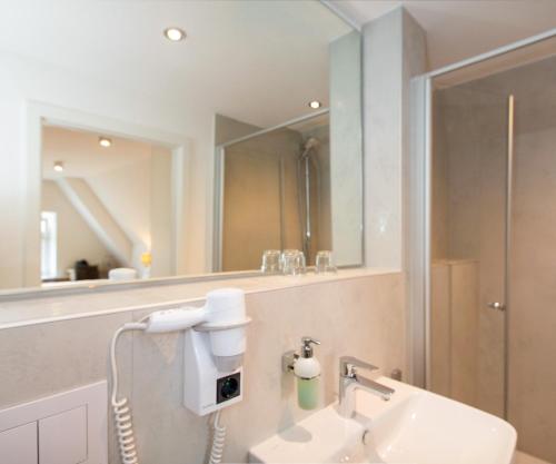 a bathroom with a sink and a mirror at Hotelgasthof Bayerischer Hof in Sulzbach-Rosenberg