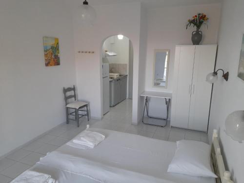 a white room with a bed and a desk at Silver view in Batsi