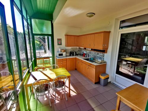 a kitchen with wooden cabinets and a table and chairs at Dolce Villa Balaton in Vonyarcvashegy