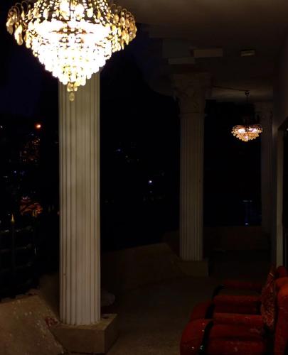 a large chandelier in a room with two columns at Sunrise Rest House in Islamabad