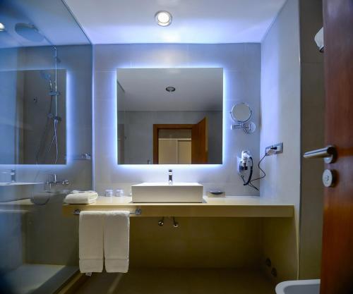 a bathroom with a sink and a mirror at La Recova Hotel & Spa in La Punta