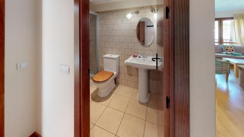 a bathroom with a toilet and a sink at Los Altos de Escarrilla - tucasaenlospirineos in Escarrilla