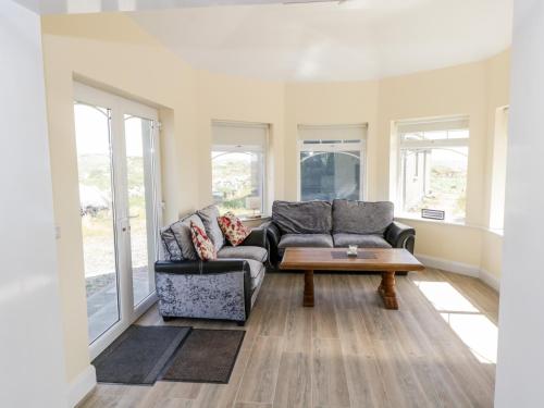 a living room with a couch and a coffee table at Tí Tom Nárta in Trawbaun