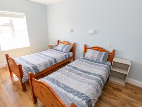 two beds sitting next to each other in a room at Tí Tom Nárta in Trawbaun