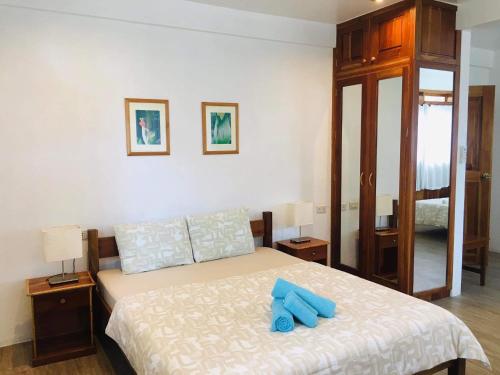 a bedroom with a bed with blue pillows on it at Pahiluna Guesthouse in Panglao