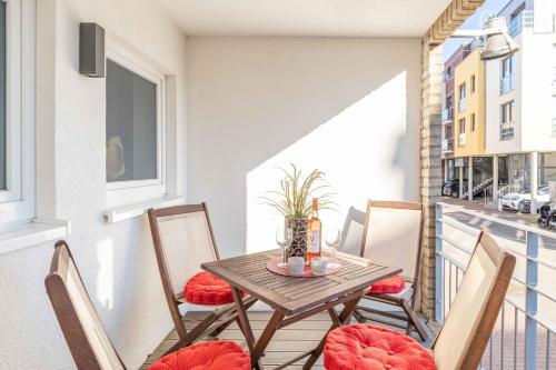 a small balcony with a wooden table and chairs at SEASIDE APARTMENTS - TOWNHOUSE in Eckernförde