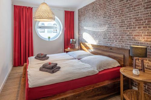 a bedroom with a bed with a brick wall at SEASIDE APARTMENTS - TOWNHOUSE in Eckernförde
