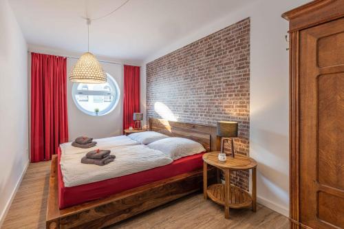 1 dormitorio con cama y pared de ladrillo en SEASIDE APARTMENTS - TOWNHOUSE en Eckernförde