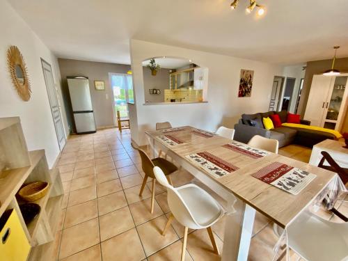 een keuken en een woonkamer met een tafel en stoelen bij Villa 6p, 3ch avec grand jardin clos, clim, village classé de Vogue in Vogüé