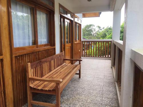 a wooden bench sitting on the porch of a house at Pahiluna Guesthouse in Panglao
