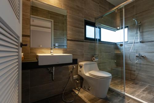 a bathroom with a toilet and a sink and a shower at Rambling Snail in Luodong