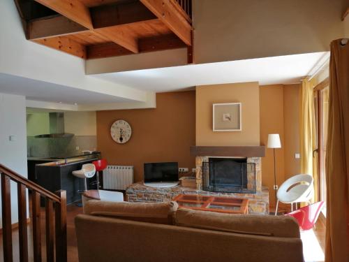 a living room with a couch and a fireplace at Los Altos de Escarrilla - tucasaenlospirineos in Escarrilla