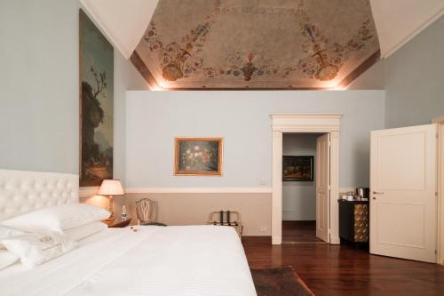 a bedroom with a bed and a painting on the ceiling at Royal Palace Hotel in Turin