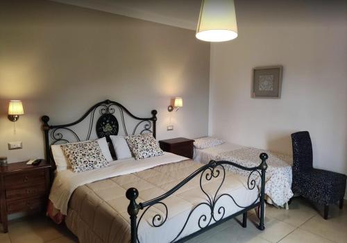 a bedroom with two beds and a chair at Villa Cristina in Pontelatone