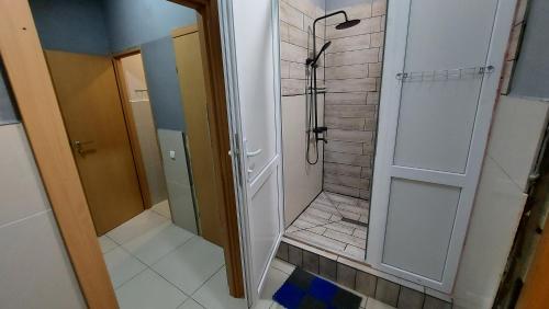 a bathroom with a walk in shower next to a door at Отель Меридиан in Zolotonosha
