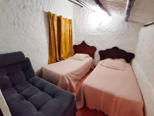 Habitación con 2 camas y sofá en Casa Florence Guatavita, en Guatavita