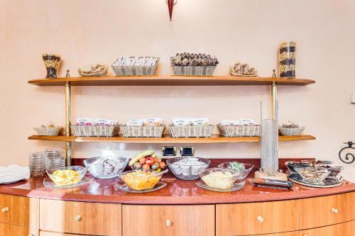 a counter with bowls and plates of food on it at HOTEL VILLA MARIA in Cesenatico