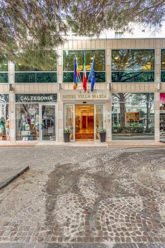 a large building with flags in front of it at HOTEL VILLA MARIA in Cesenatico