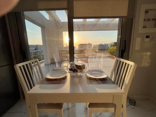 a dining room table with a view of a balcony at BlueLine apartment 2 in Loutraki