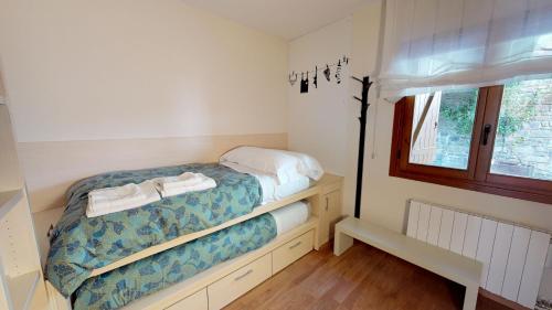 a small bedroom with a bed and a window at Los Altos de Escarrilla - tucasaenlospirineos in Escarrilla
