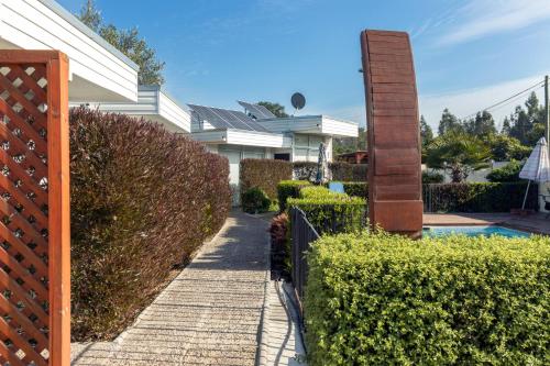 a fence next to a house with a pool at Cabañas Rio Rapel in Rapel