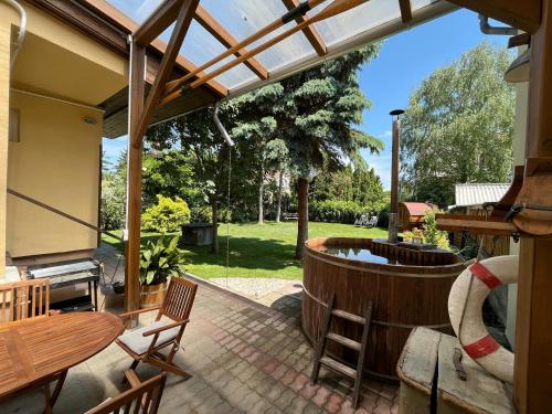 a patio with a hot tub and a table and chairs at Abigél Vendégház Keszthely in Keszthely