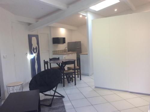 un salon avec une table et des chaises et une cuisine dans l'établissement Les palmiers, à Nice