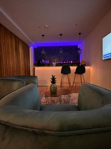 een woonkamer met banken en een bar met paarse verlichting bij Villarit Porto in Gondomar