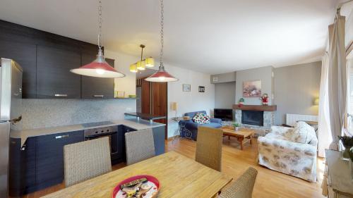 a kitchen and living room with a table and a dining room at Los Altos de Escarrilla - tucasaenlospirineos in Escarrilla