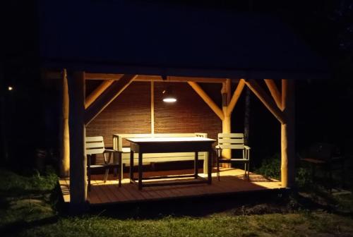 a table and chairs on a deck at night at Na Skraju Szlaków in Sernetki