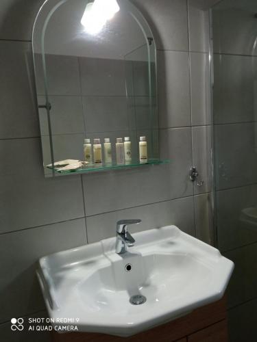 a bathroom with a sink and a mirror at Studios Dimitra in Spartià
