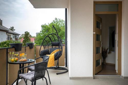 a patio with chairs and a table on a balcony at TREND BA HOME Apartman in Balatonalmádi