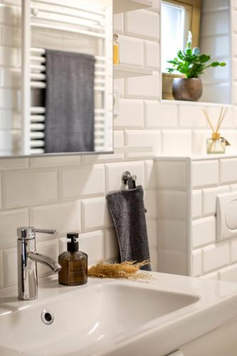 a bathroom sink with a soap dispenser on it at TREND BA HOME Apartman in Balatonalmádi