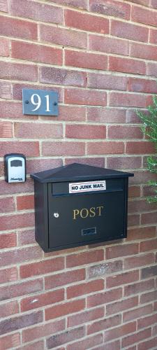 a post box on the side of a brick wall at SQUIRRELSTONE in Gurnard