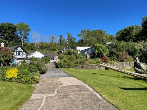 a walkway through a garden with houses in the background at Pentre Cerrig Country House in Llanferres