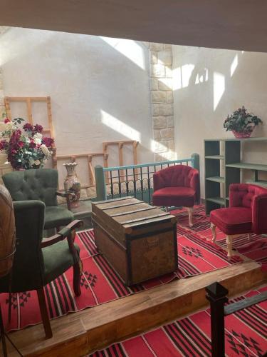 a room with chairs and a trunk on a rug at Alf leila wa leila boutique in Haifa