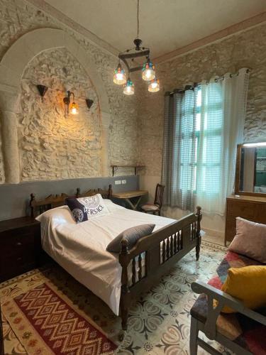 a bedroom with a large bed and a stone wall at Alf leila wa leila boutique in Haifa
