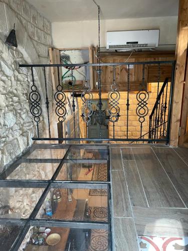 a glass staircase in a room with a stone wall at Alf leila wa leila boutique in Haifa