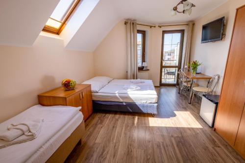 a small room with two beds and a table at Willa Ewa in Międzyzdroje