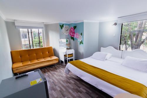 a bedroom with a large bed and a couch at ApartaSuites & Hotel Bogota Suamox in Bogotá